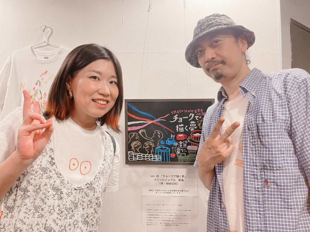 「チョークで描く夢」のミニポスターを真ん中に、左に山田、右に中津留さんで記念写真を撮りました。ちなみに山田は髪の毛を肩くらいの長さにキリましてイメチェンしたばかりの頃です！