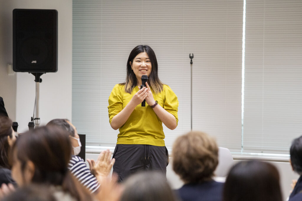 マイクをもつ山田が笑顔で進行している様子